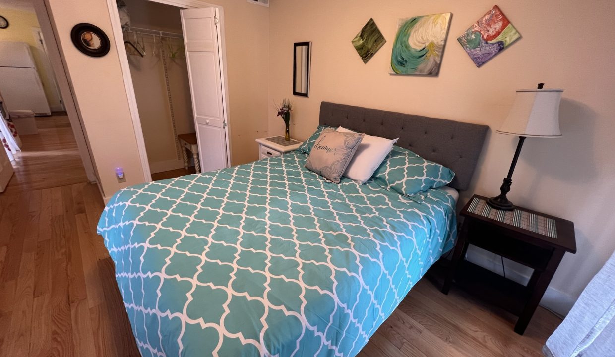 a bed with a blue and white comforter in a bedroom.