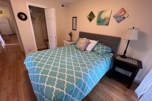 a bed with a blue and white comforter in a bedroom.