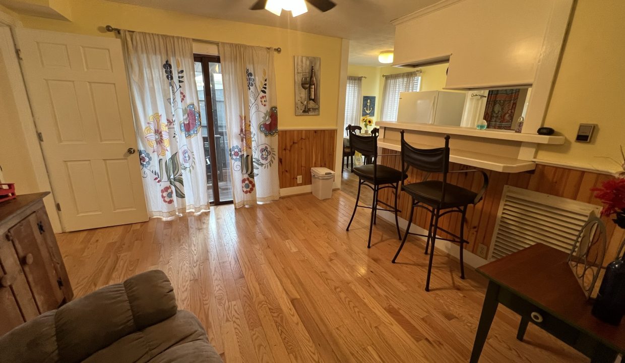 a living room filled with furniture and a wooden floor.