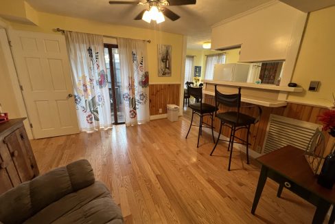 a living room filled with furniture and a wooden floor.