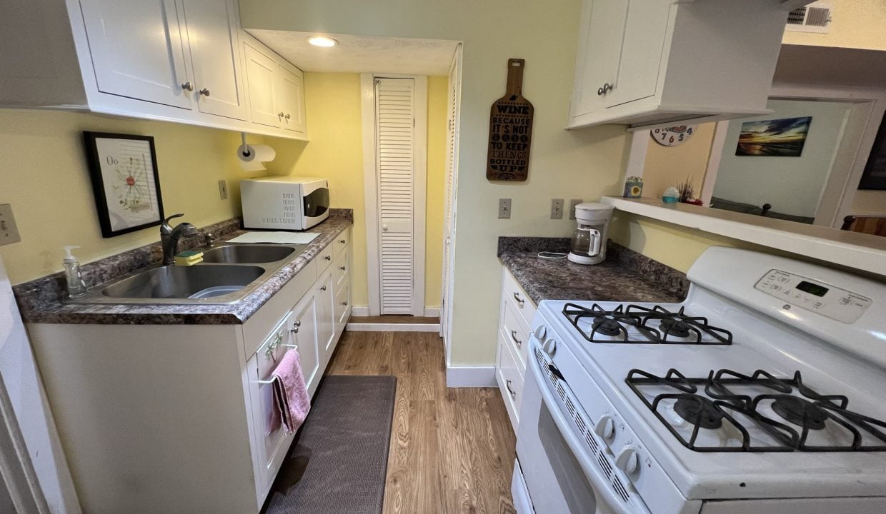 a kitchen with a stove, sink, and refrigerator.