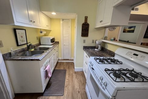 a kitchen with a stove, sink, and refrigerator.