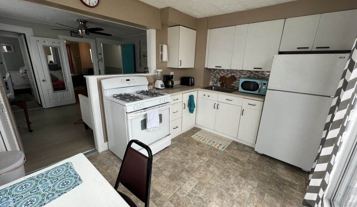 a kitchen with a table, stove, and refrigerator.