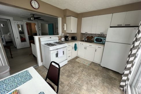 a kitchen with a table, stove, and refrigerator.