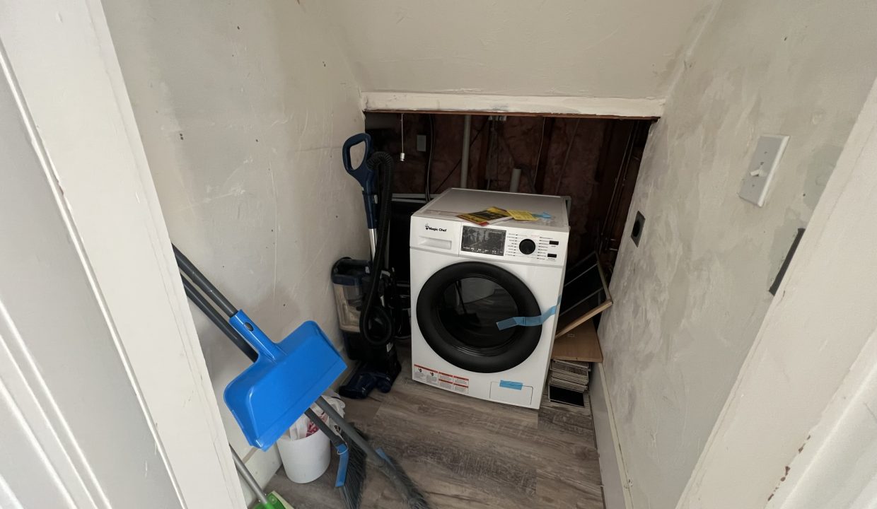 a white washer sitting in the corner of a room.