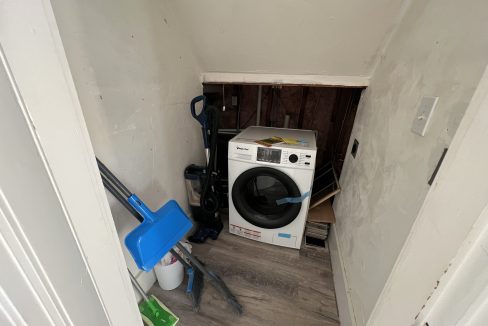 a white washer sitting in the corner of a room.