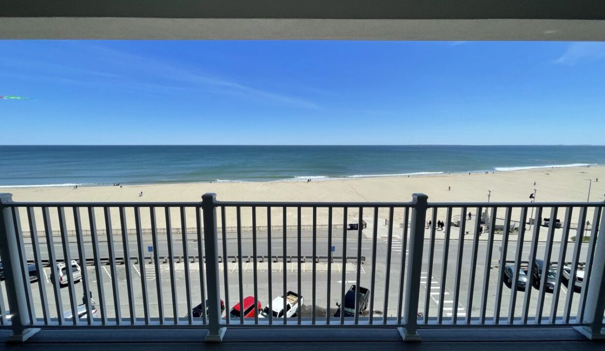 a balcony with a view of the beach and ocean.