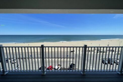 a balcony with a view of the beach and ocean.