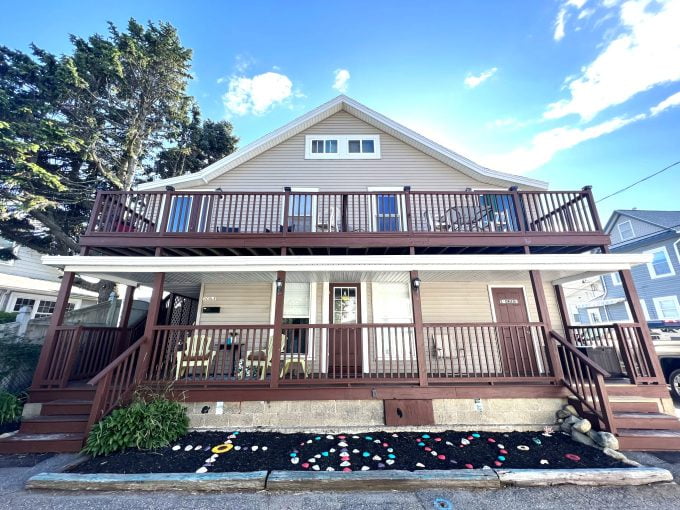 a two story house with a deck and stairs.