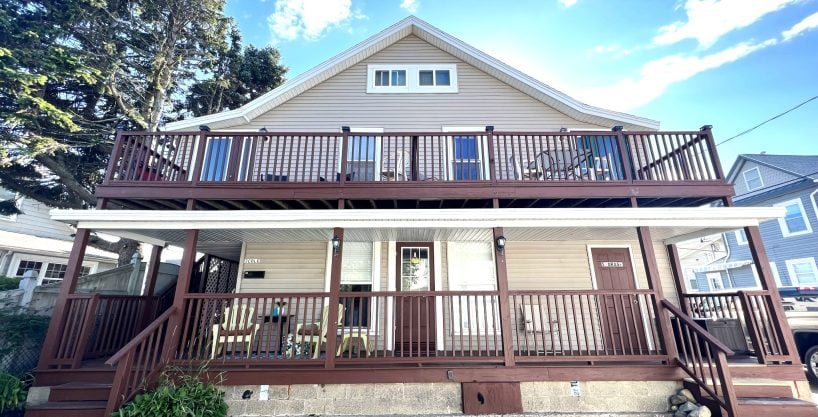 a two story house with a deck and stairs.