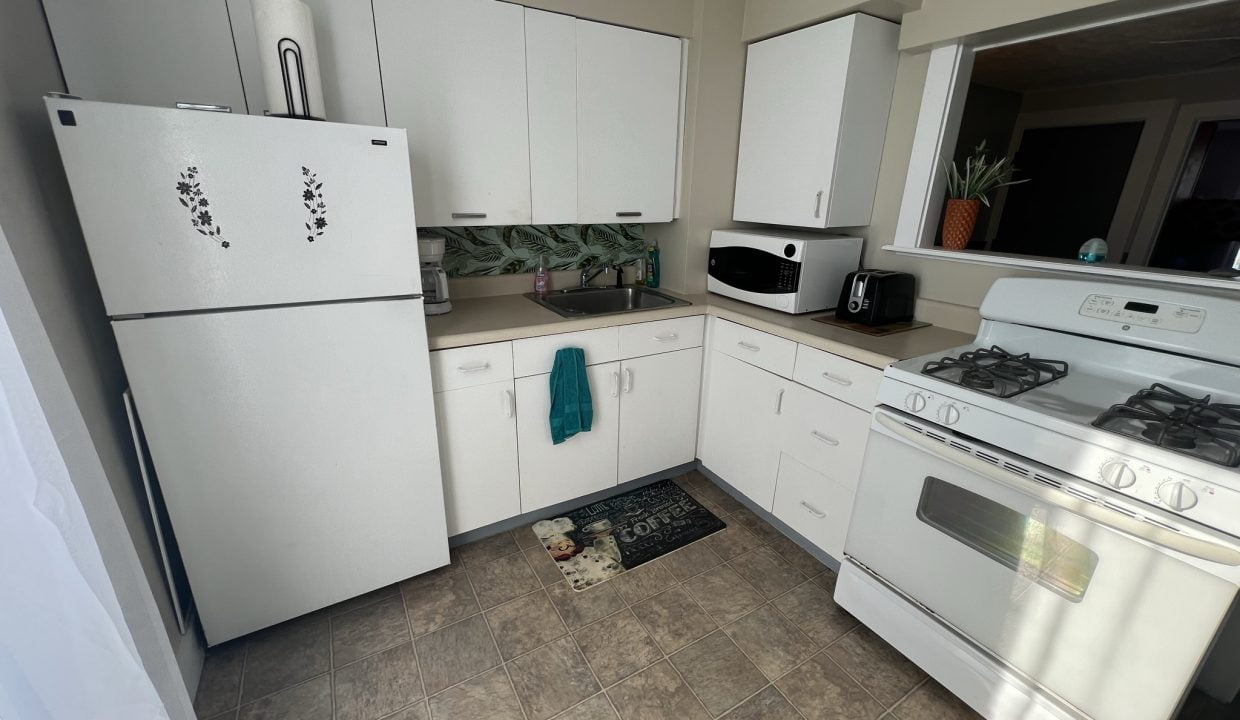 a kitchen with white appliances and white cabinets.