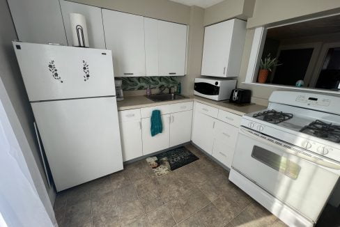 a kitchen with white appliances and white cabinets.