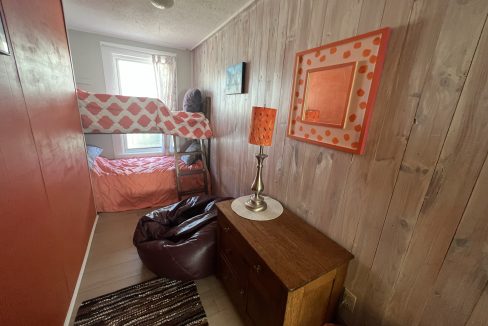 a bedroom with a bunk bed and a dresser.