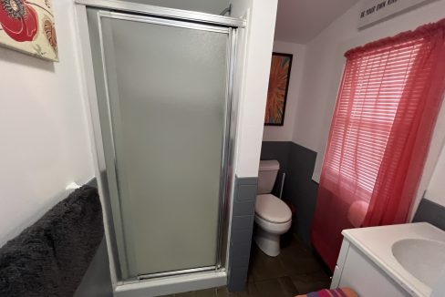 a bathroom with a shower, toilet and sink.