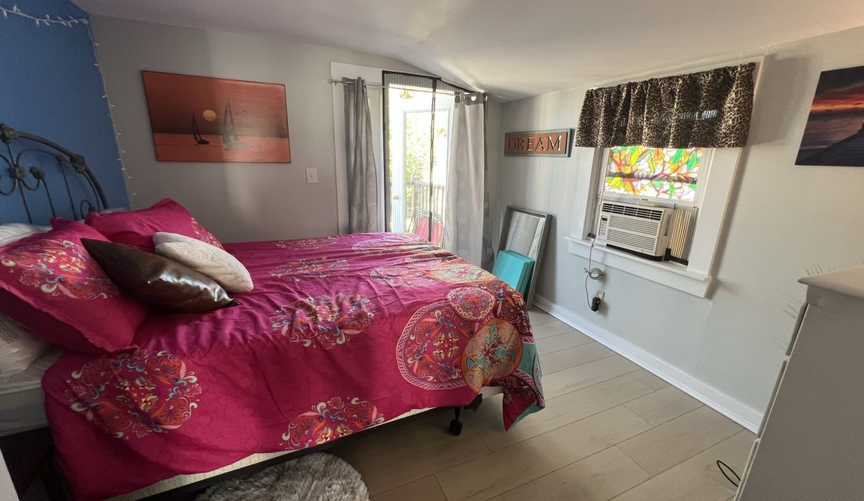 a bed room with a neatly made bed and a window.