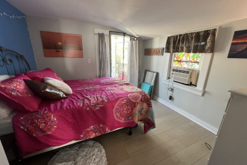 a bed room with a neatly made bed and a window.