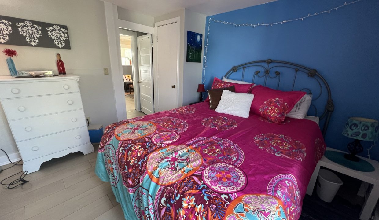 a bedroom with blue walls and a pink bed.