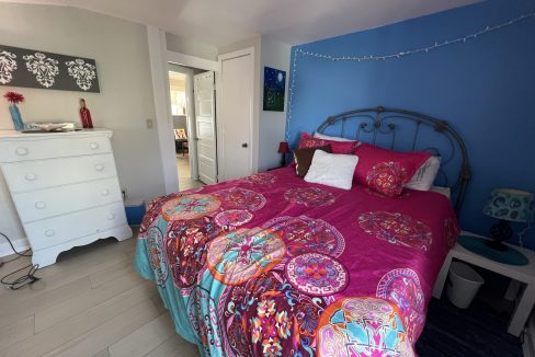 a bedroom with blue walls and a pink bed.