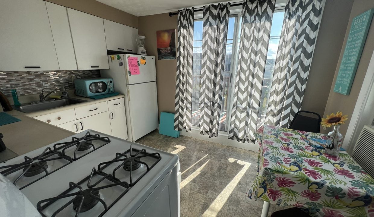 a kitchen with a stove top oven next to a window.