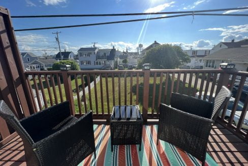 two wicker chairs sitting on a wooden deck.