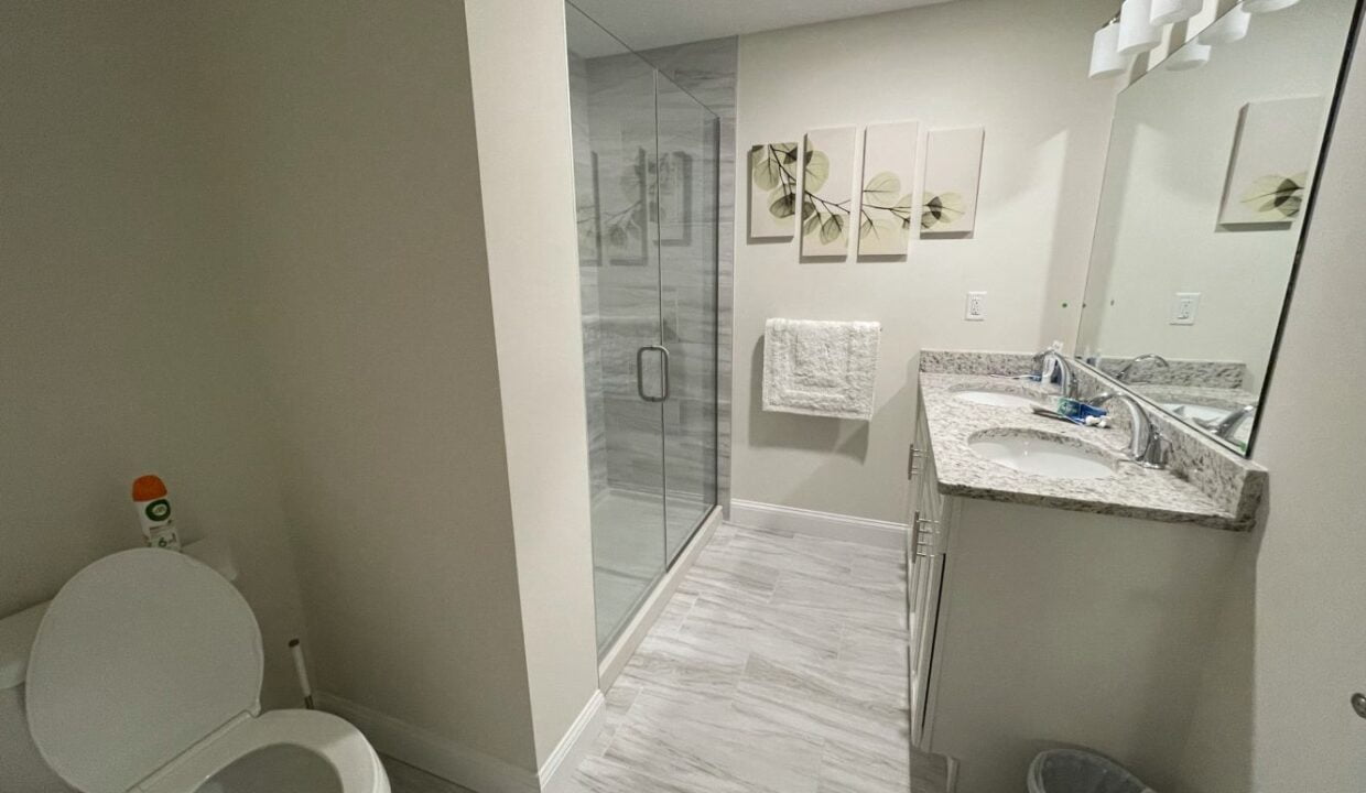 a white toilet sitting next to a walk in shower.