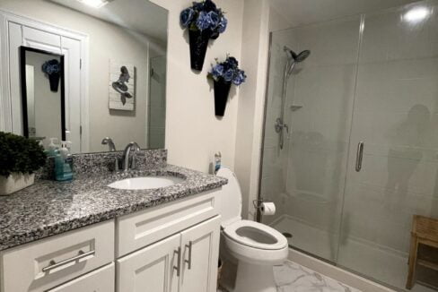 a bathroom with a toilet, sink, and shower.