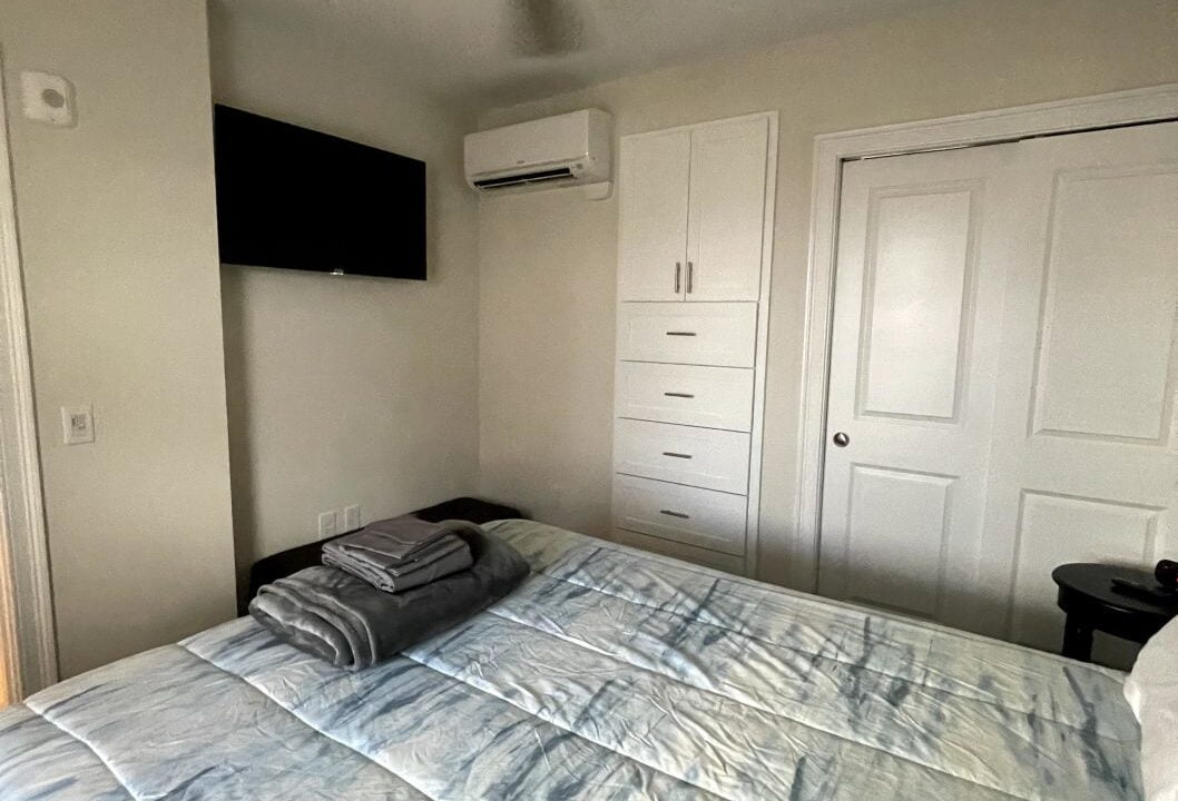 a bedroom with a bed and a ceiling fan.