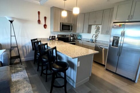 a kitchen with a center island next to a living room.