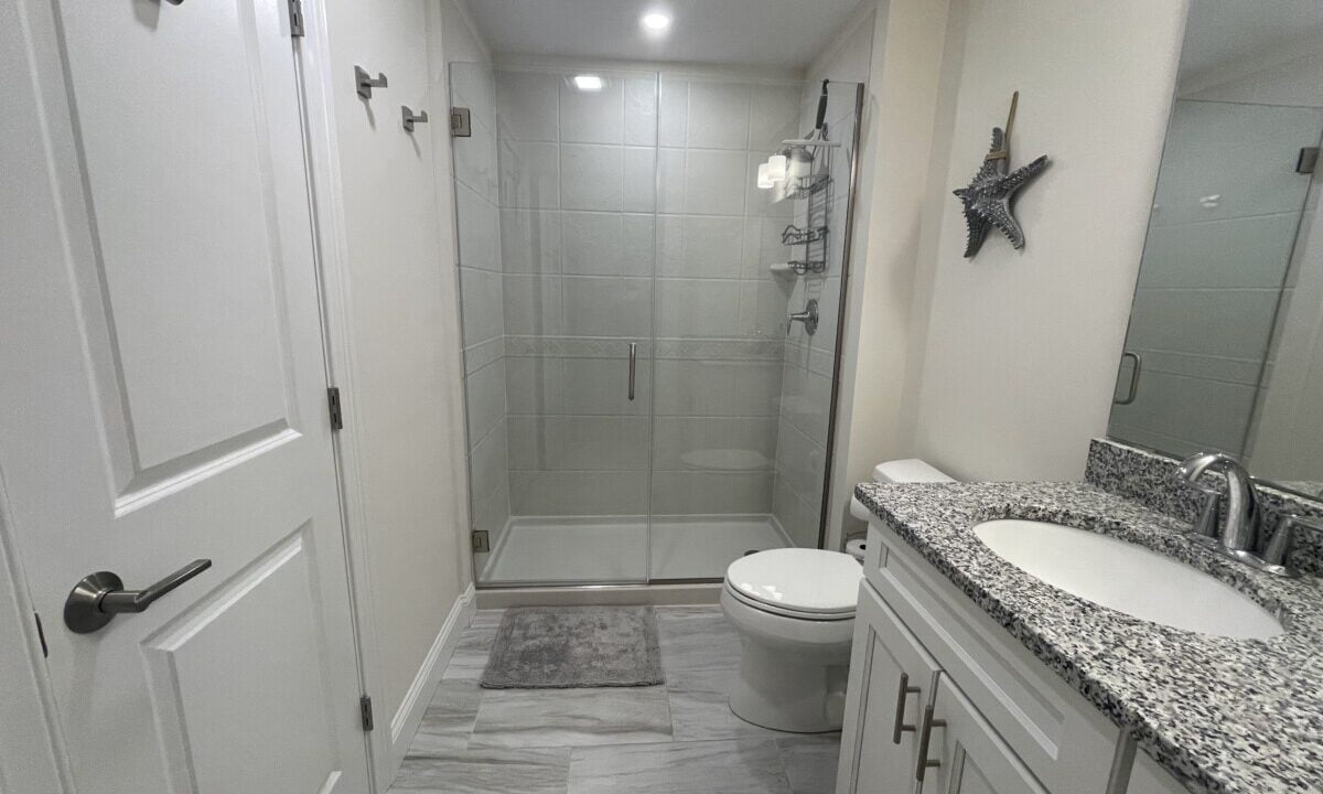 a bathroom with a walk in shower next to a toilet.