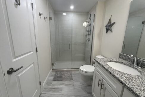 a bathroom with a walk in shower next to a toilet.