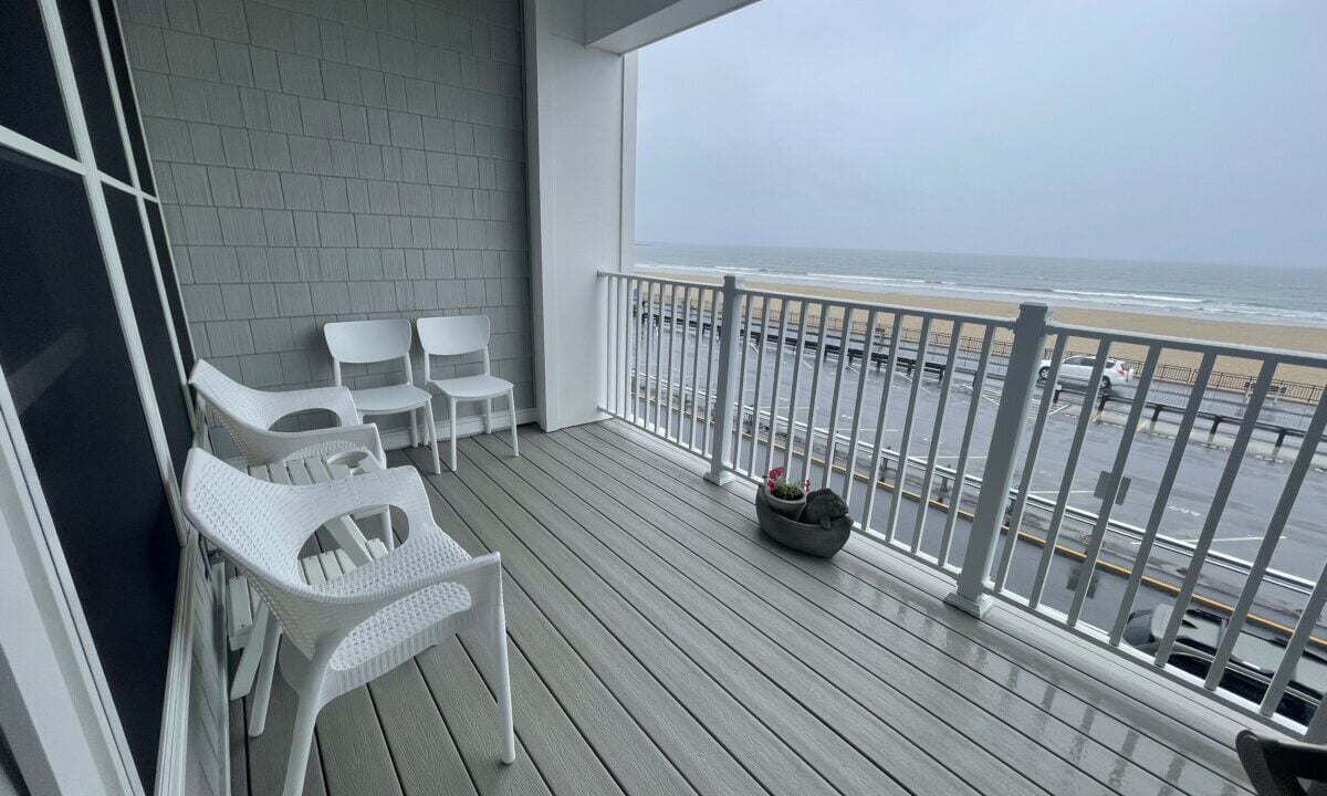 a balcony with chairs and a potted plant on it.