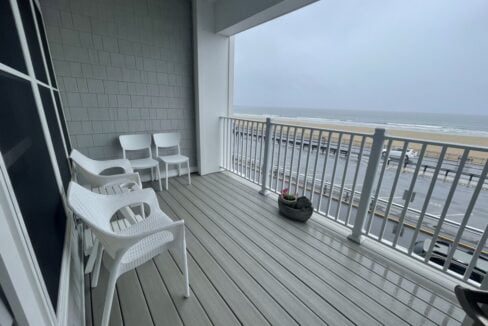 a balcony with chairs and a potted plant on it.