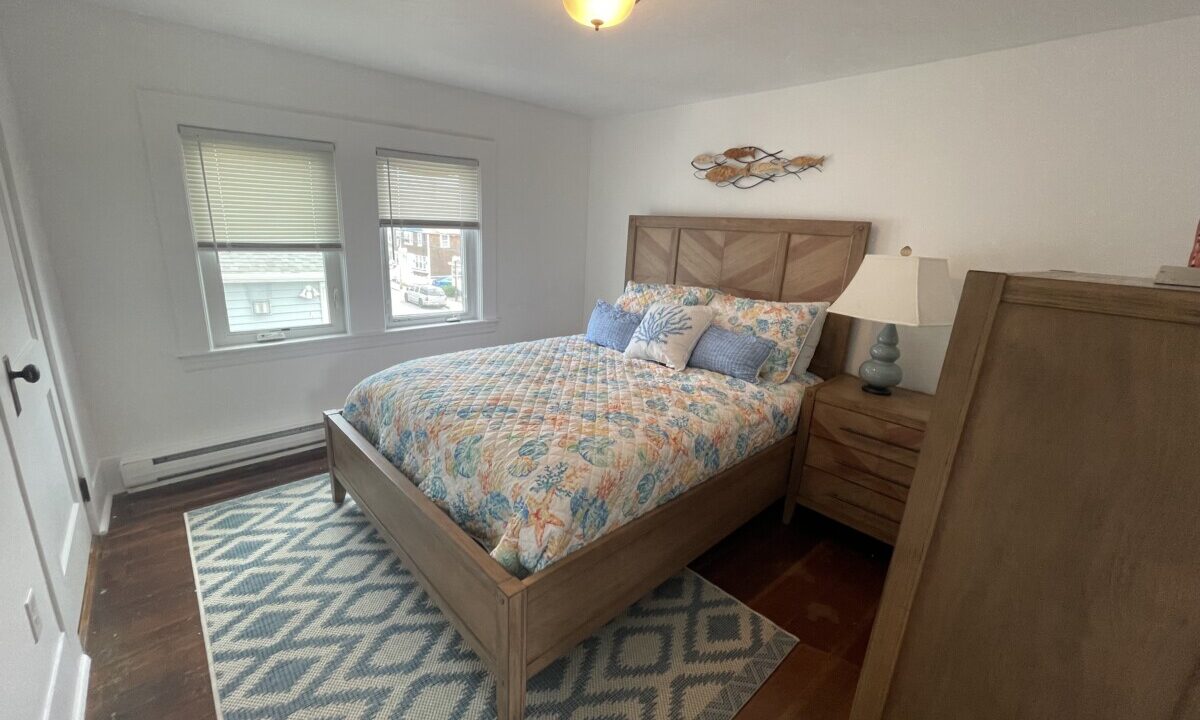 a bed room with a neatly made bed and a dresser.