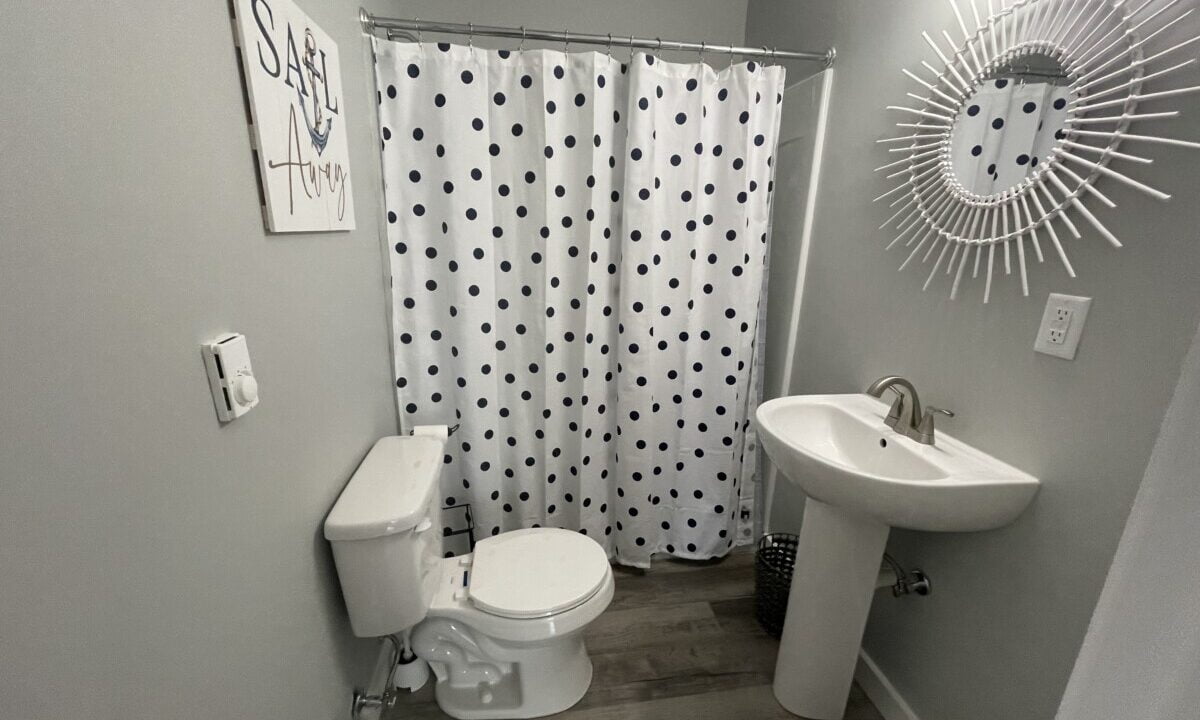 a white toilet sitting next to a sink in a bathroom.