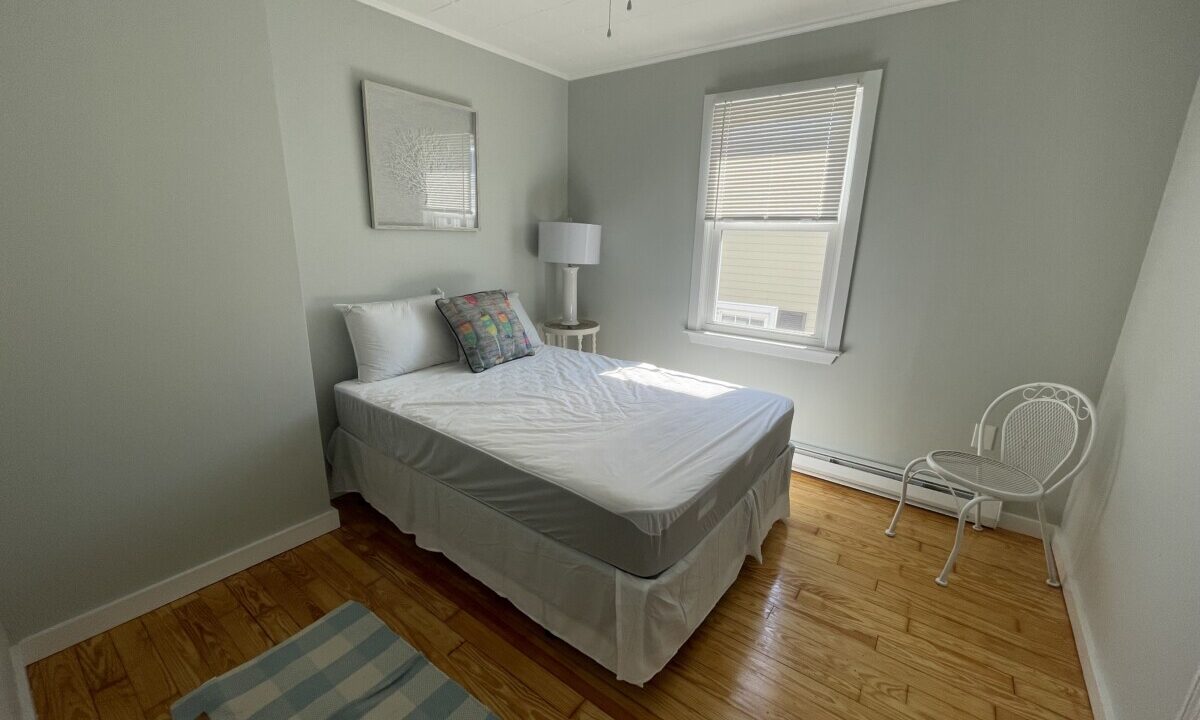 a bed sitting in a bedroom next to a window.