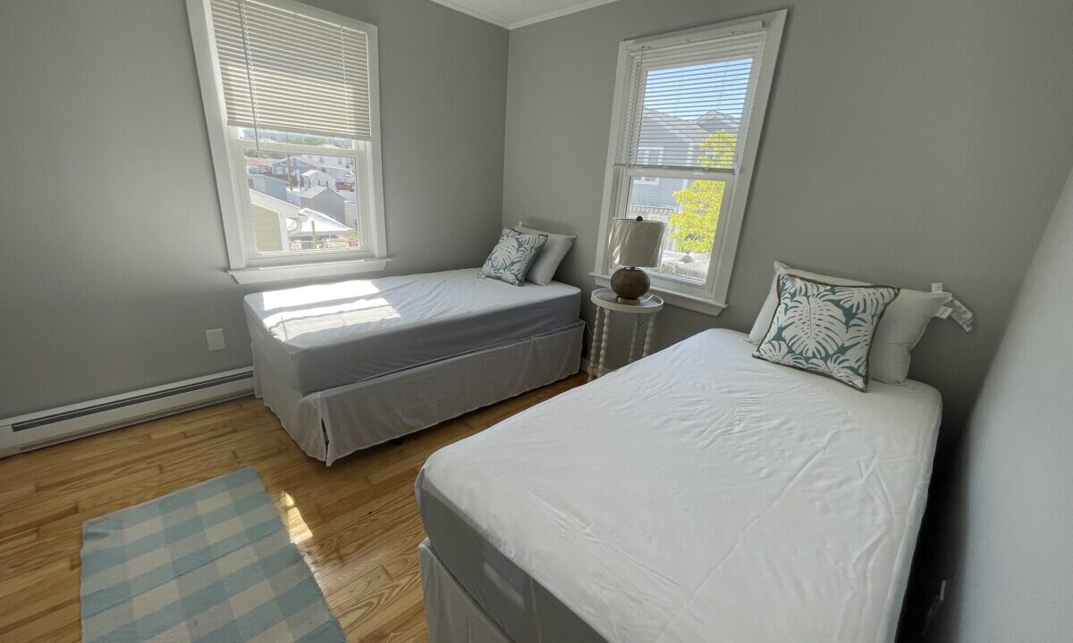 a bed room with two beds and a window.