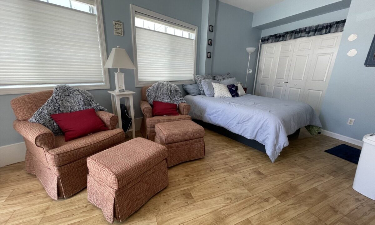 a bedroom with a bed and two chairs.