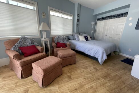 a bedroom with a bed and two chairs.