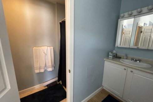 a bathroom with blue walls and white cabinets.