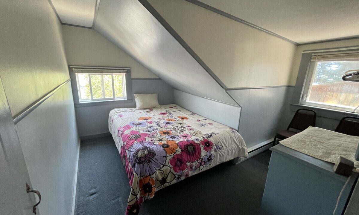 a bedroom with a bed and a desk in it.