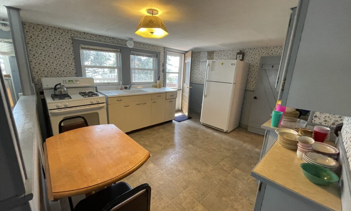 a kitchen with a table and a refrigerator.
