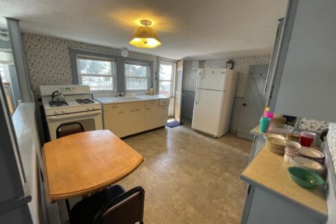 a kitchen with a table and a refrigerator.