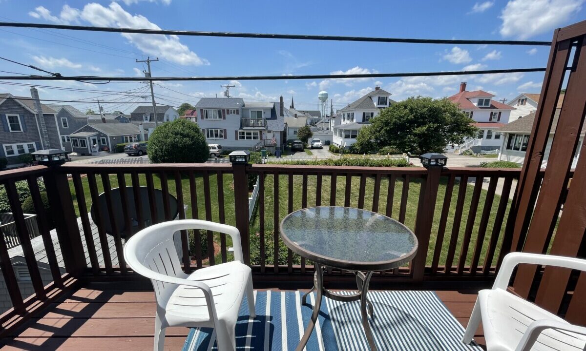 two chairs and a table on a deck.