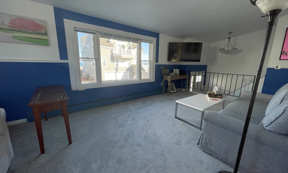 a living room with blue walls and a gray couch.