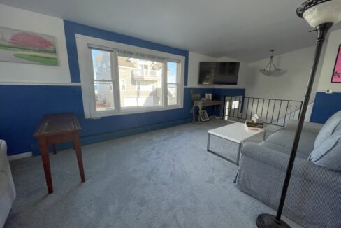 a living room with blue walls and a gray couch.