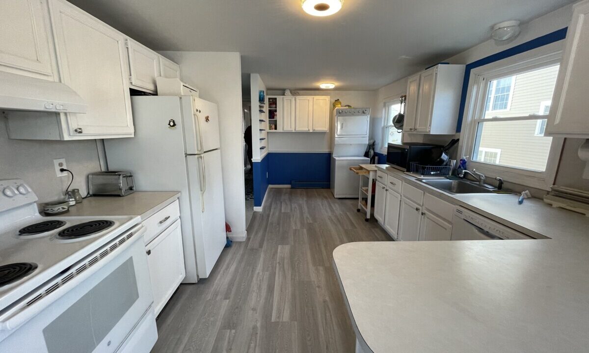 a kitchen with white appliances and white cabinets.