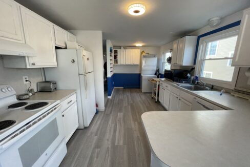 a kitchen with white appliances and white cabinets.