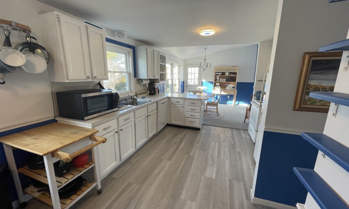 a kitchen with white cabinets and blue trim.