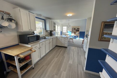 a kitchen with white cabinets and blue trim.