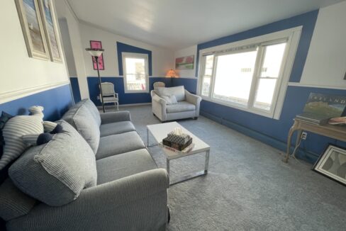 a living room with blue walls and a gray couch.